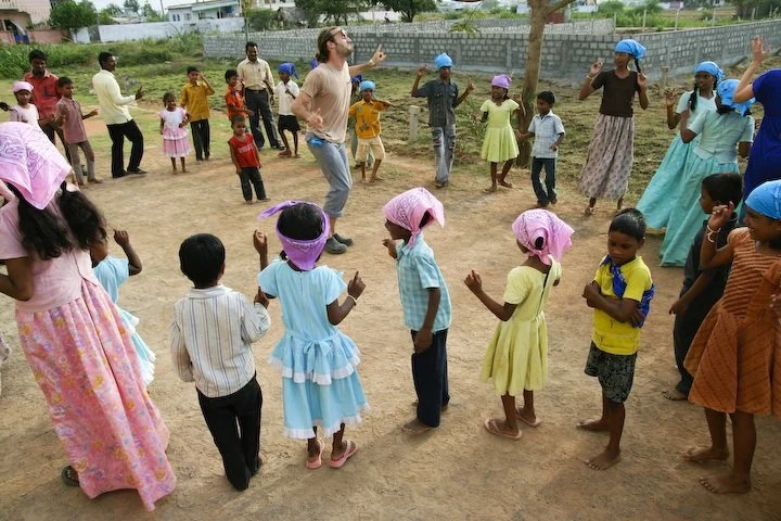 Children and caregivers sharing an outdoor activity at Vikasitha Ministries